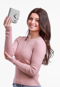 Gray wallet featuring a textured surface, rectangular shape, and a front clasp. Held by a person wearing a pink ribbed sweater.