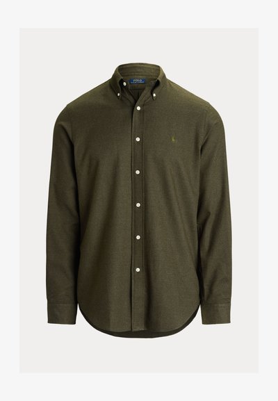 Oliivivärinen nappikauluspaita pehmeästä kankaasta, jossa on kaulus, pitkät hihat ja pyöristetty helma. Pieni logo vasemmassa rinnassa.