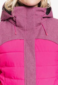 Giacca puffa rosa con cappuccio e pannello frontale in un rosa più chiaro e strutturato. Presenta cordini regolabili e una fodera nera liscia.