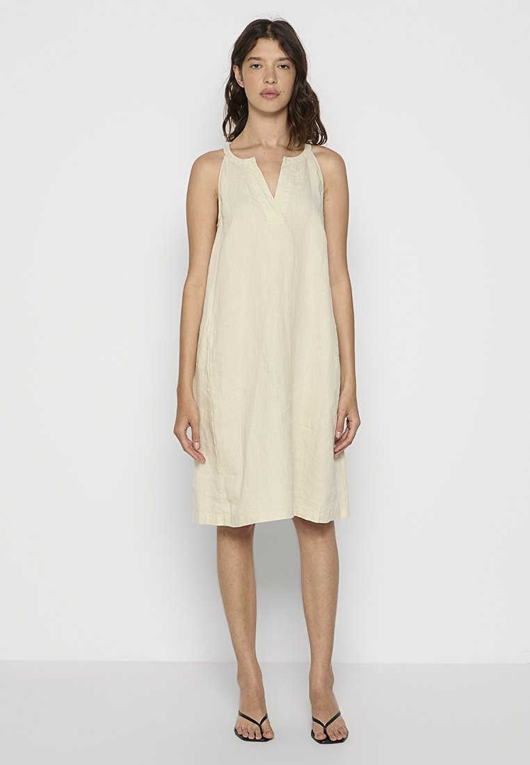 Beiges Leinenkleid mit V-Ausschnitt, ärmellosem Design und lässiger Passform, das knapp über den Knien endet. Leichter, texturierter Stoff.