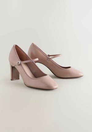 Rosa lacklederne High Heels mit einer spitzen Zehenform, Spitzenrand entlang der Kante und einem Kreuzriemen-Detail.