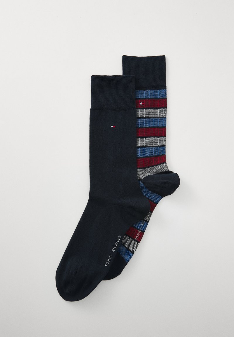 Chaussettes bleu marine foncé avec une texture lisse, présentant un motif rayé en rouge, bleu et gris d'un côté ; logo sur la semelle.