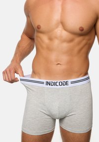 Grijze katoenen boxershorts met een witte tailleband, met de merknaam "INDICODE" en een zwart streep detail.
