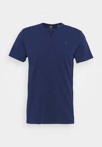 Camiseta de manga corta azul marino hecha de algodón suave. Presenta un cuello redondo y un pequeño logo en el pecho, con un corte clásico y una textura suave.