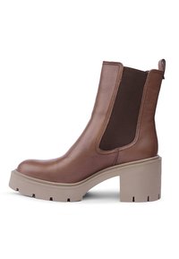 Botín de cuero marrón con paneles laterales elásticos, suela gruesa en beige y una lengüeta en la parte trasera; diseño elegante y moderno.