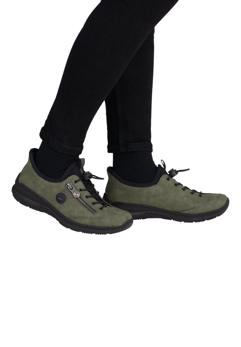 Sneakers in suede verde con dettagli neri, dotati di una chiusura con zip, lacci e una suola in gomma nera strutturata.