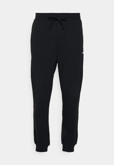 Pantalons de survêtement noirs en mélange de coton, avec une taille élastique dotée d'un cordon de serrage ajustable, des poignets côtelés et un petit logo en détail.