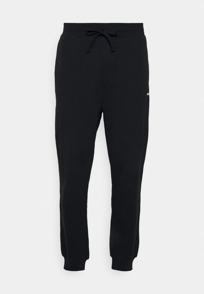 Pantalons de survêtement noirs en mélange de coton, avec une taille élastique dotée d'un cordon de serrage ajustable, des poignets côtelés et un petit logo en détail.