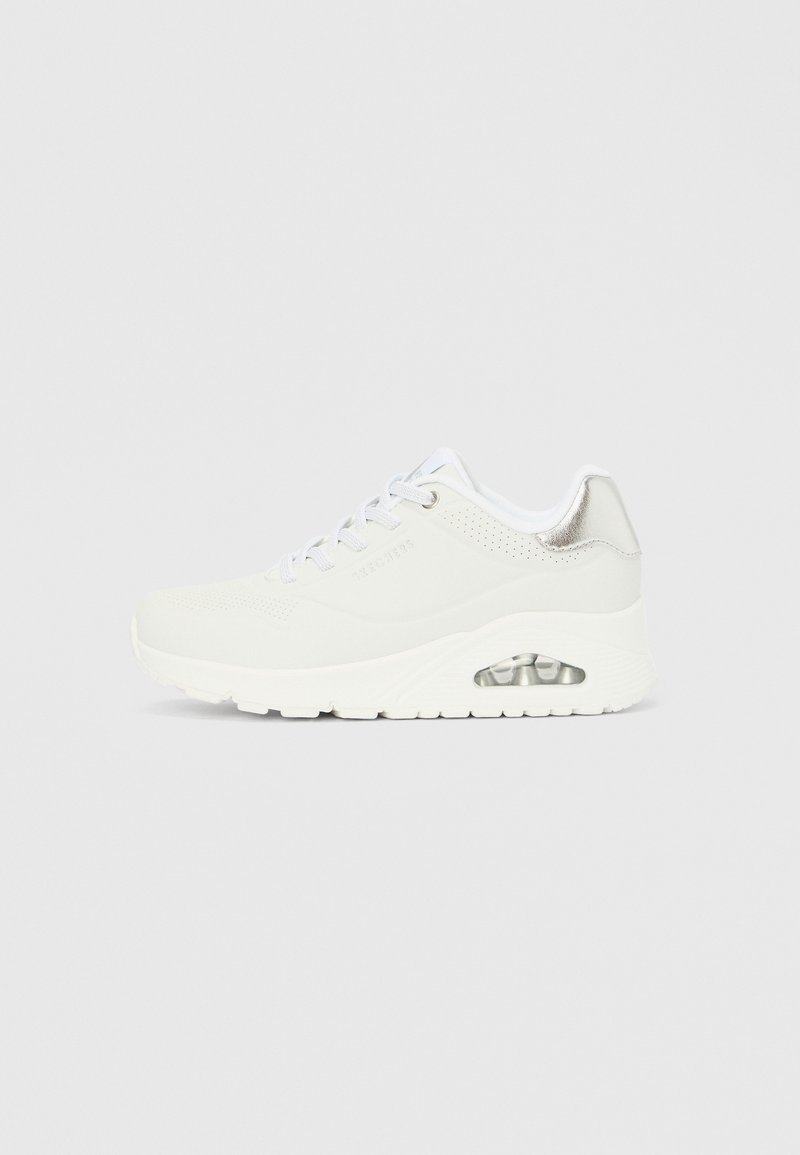 Pantof sportiv alb cu suprafață netedă, detalii perforate pe laterale, accente argintii pe călcâi și amortizare cu aer vizibilă în talpă.