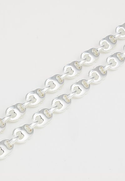 Catena in metallo argento con maglie arrotondate e disegni intagliati, superficie lucidata, texture liscia e due filamenti paralleli.
