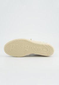 Suela de zapatilla beige con texto en relieve "paul green", patrón de agarre texturizado y diseño circular pequeño cerca del talón.