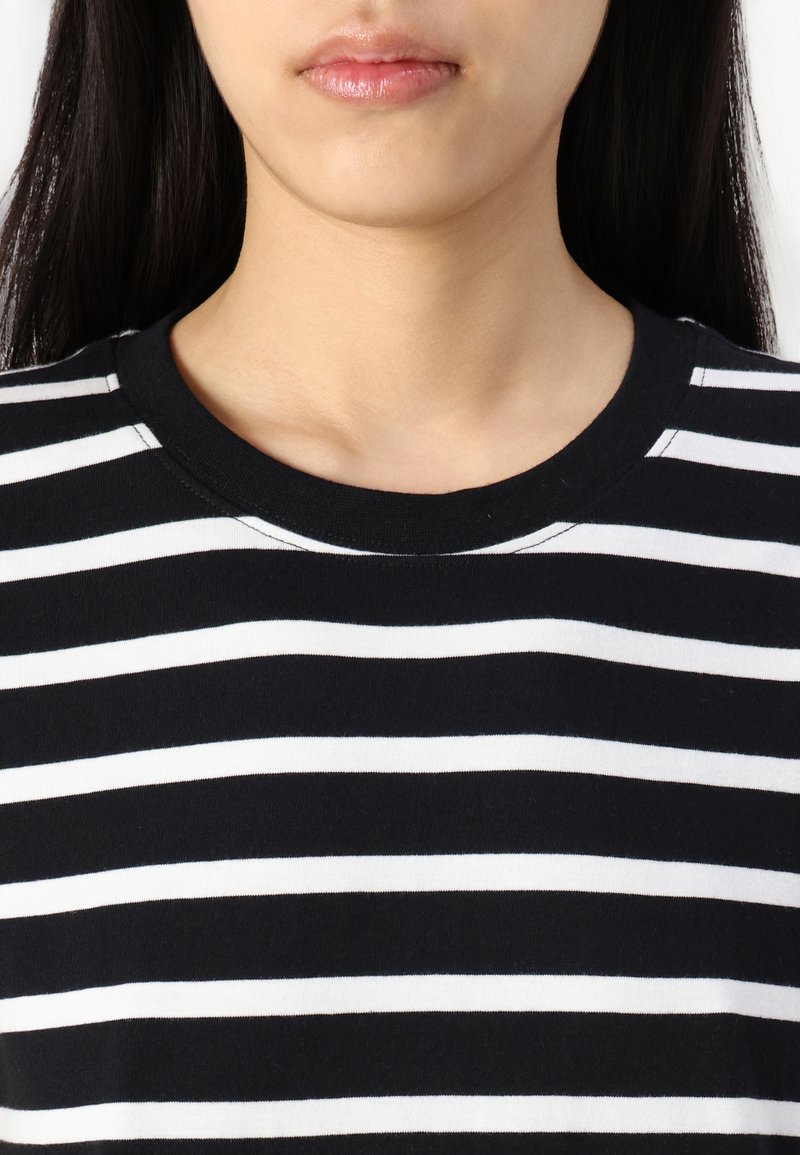 Schwarz-weißer gestreifter T-Shirt mit Rundhalsausschnitt. Der Stoff wirkt weich, und die Streifen sind gleichmäßig verteilt und horizontal.