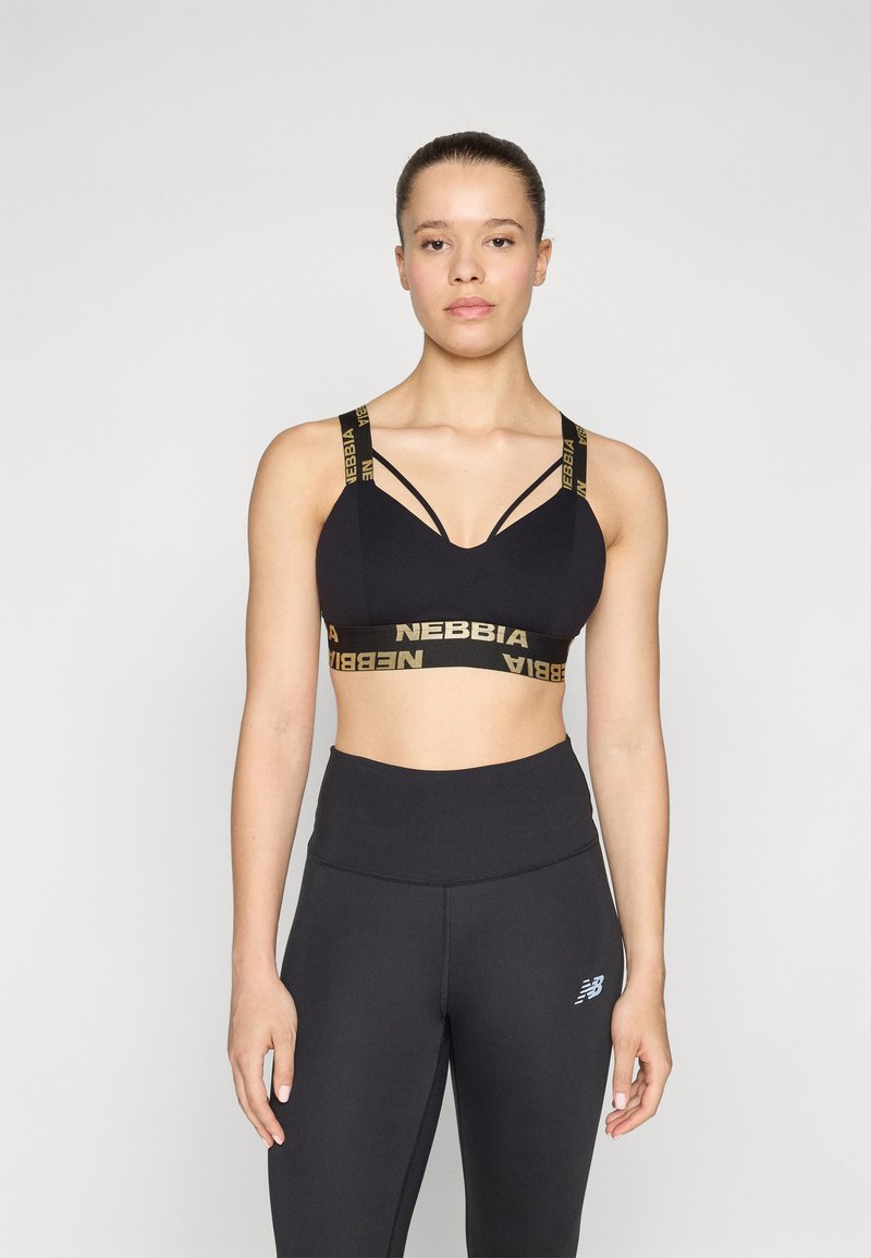 Sujetador deportivo negro con el logo dorado "NEBBIA", con un diseño de escote en V y doble tirante. Combinado con leggings negros de talle alto.
