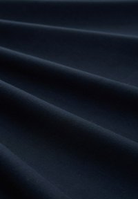 Tissu bleu marine à la texture lisse, avec de légers plis et une surface uniforme. Le matériau semble épais et durable.