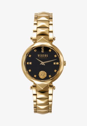 Reloj en tono dorado con caja redonda, esfera negra texturada, detalle de león dorado y marcadores de hora cuadrados. Cuenta con una pulsera de acero inoxidable.