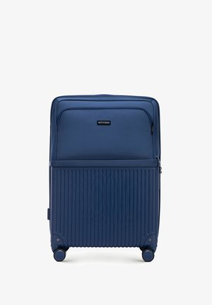 Valigia rigida blu navy con scanalature verticali, doppie ruote, scomparti con zip e una tasca frontale. Logo del marchio visibile sulla parte anteriore.