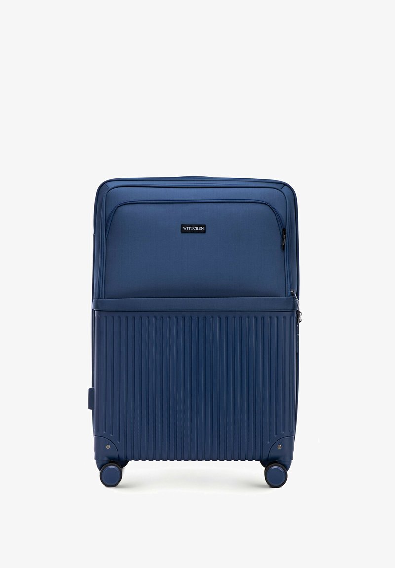 Maleta rígida azul marino con surcos verticales, ruedas dobles, compartimentos con cremallera y un bolsillo frontal. Logotipo de la marca visible en la parte delantera.