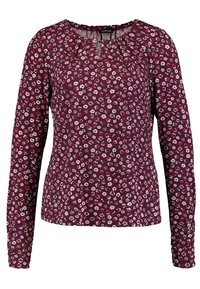 Blusa a maniche lunghe realizzata in tessuto leggero, con uno sfondo bordeaux e piccoli motivi floreali in rosa e bianco. Collo rotondo.