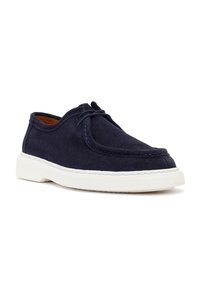 Navy blue suede casual shoe with white rubber sole, lace-up front, and moccasin-style stitching around the toe area.