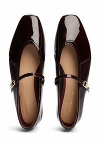 Scarpe Mary Jane in vernice bordeaux con punta quadrata, una cintura con una fibbia dorata e una fodera interna beige liscia.