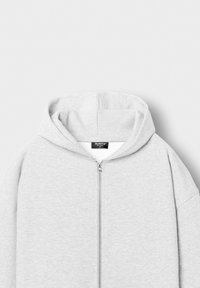 Light grey zip-up hoodie with a front zipper and attached hood, shown laid flat against a plain background.