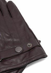 Brązowe rękawiczki ze skóry o gładkiej fakturze, wyposażone w zapięcie na guzik i ozdobne przeszycia.