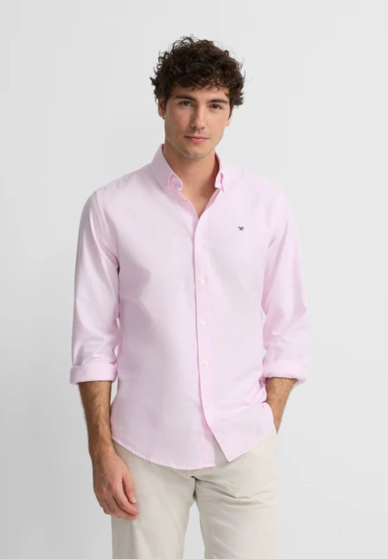 Camisa de botones rosa claro con mangas enrolladas, que presenta un pequeño logo en el pecho. Hecha de una suave tela de algodón.