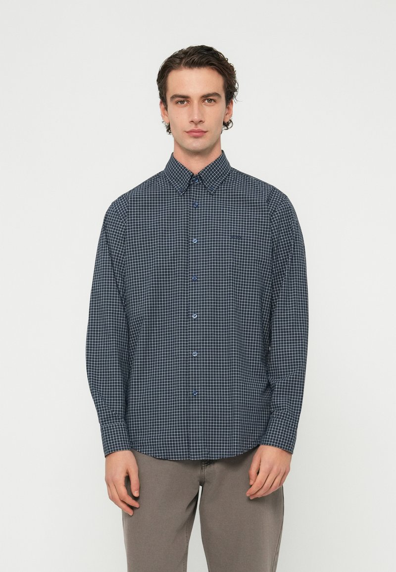 Tengerészkék kockás ing patentos gallérral, kék gombokkal, hosszú ujjakkal és laza szabással, könnyű anyagból készült.