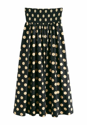 Schwarzes trägerloses Kleid mit geraffter Taille und großen beigen Polka-Punkten, die die gesamte Länge des Rocks bedecken.