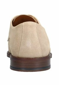 Beige Wildlederschuh mit abgerundeter Ferse, Lederfutter und einem dunkelbraunen gestapelten Absatz. Mit genähten Akzenten entlang der Nähte.