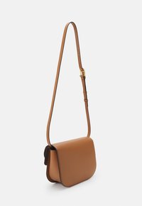 Brun läder crossbody-väska med en platt design, justerbar axelrem och subtila sömnadsdetaljer längs kanterna. Slät textur.