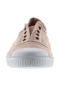 Zapatilla de lona rosa claro con suela de goma blanca. Presenta ojales de metal y punta redondeada. Diseño simple y de perfil bajo con detalles de costura.