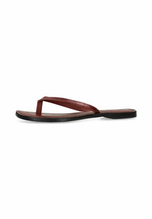 Sandale en cuir marron à bride tong avec une semelle plate noire, vue de profil sur fond blanc.