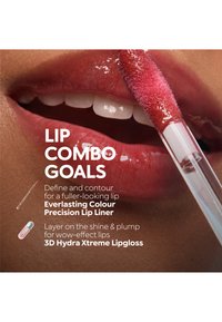 Gros plan sur des lèvres avec un applicateur de gloss à lèvres rouge brillant, appliquant le 3D Hydra Xtreme Lipgloss pour une finition brillante et pulpeuse.
