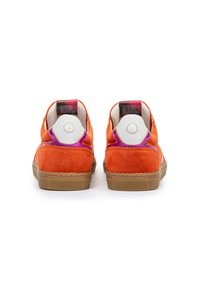 Oranssinväriset mokkakenkäparit kumipohjalla. Sisältää erottuvat violetit yksityiskohdat kantaosassa ja pehmustetun vartalon. Rakenteellinen pinta.