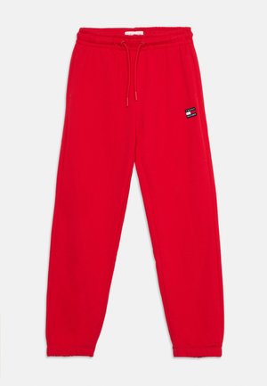 Røde joggingbukser med elastisk talje og snøre, sidelommer og et lille rektangulært Tommy Hilfiger-logo på højre lår.