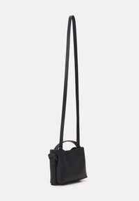 Sort læder crossbody taske med en struktureret form, tynd justerbar rem og et lille top håndtag. Glat tekstur, minimalistisk design.