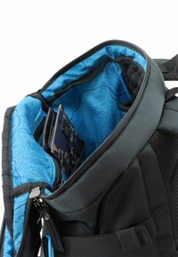 Mochila negra con un interior de patrón azul, que cuenta con un compartimento principal con cremallera, bolsillos interiores y detalles de malla en los lados.