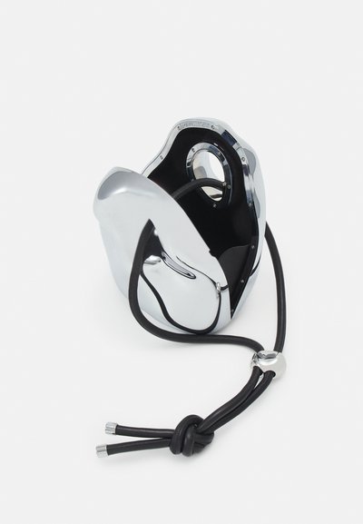 Accesoriu metalic de culoare cromată, cu o formă netedă și sculpturală, având interior negru și un cablu negru cu accente argintii.