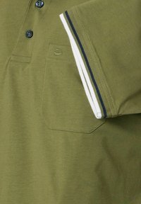 Oliwkowa bawełniana koszulka polo z trzema guzikami, kieszonką na piersi oraz krótkimi rękawami z białymi i granatowymi paskami na dolnym brzegu.