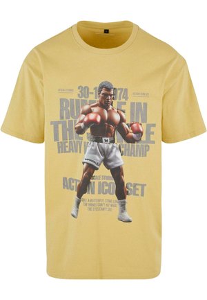 Kollane puuvillane T-särk, millel on graafiline trükk poksijast kindades, tekst ürituse kuupäevaga ja slogan all, lühikesed varrukad ning ümar kaelus.