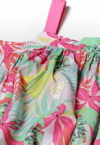 Tissu à motif floral mettant en avant des couleurs vives de rose, vert et jaune. Texture douce avec des plis froncés et un détail de sangle rose.