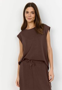 Brown short-sleeved top made of soft fabric, paired with a matching drawstring skirt featuring side pockets. Smooth texture and relaxed fit.
