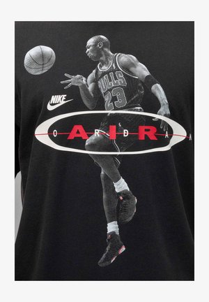 Czarny bawełniany t-shirt z grafiką skaczącego koszykarza, z logo "NIKE" i napisem "AIR" w czerwonym kolorze wyeksponowanym na środku.