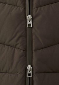 Brązowa ocieplana kurtka z centralnym zamkiem błyskawicznym z srebrnymi elementami, pikowaną fakturą i kontrastowym materiałem wzdłuż linii zamka.