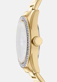 Orologio dorato con cassa rotonda, finitura liscia e lunetta incrustata di cristalli. Il bracciale è in metallo dorato con maglie intrecciate.