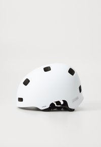 Casco sportivo bianco con finitura opaca, numerosi fori di ventilazione e cinturino regolabile. Logo del marchio stampato sul lato.
