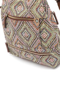 Sac multicolore à motifs en tissu texturé, présentant des formes de diamant, avec des accents en cuir marron et une poche zippée.