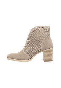 Bottine en suède beige avec panneaux en mesh, bout pointu et clous décoratifs, dotée d'un talon moyen en bloc et d'une semelle texturée.