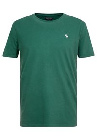 Grünes Baumwoll-T-Shirt mit kurzen Ärmeln und Rundhalsausschnitt. Mit einem kleinen weißen Logo auf der linken Brust. Glatte Textur.